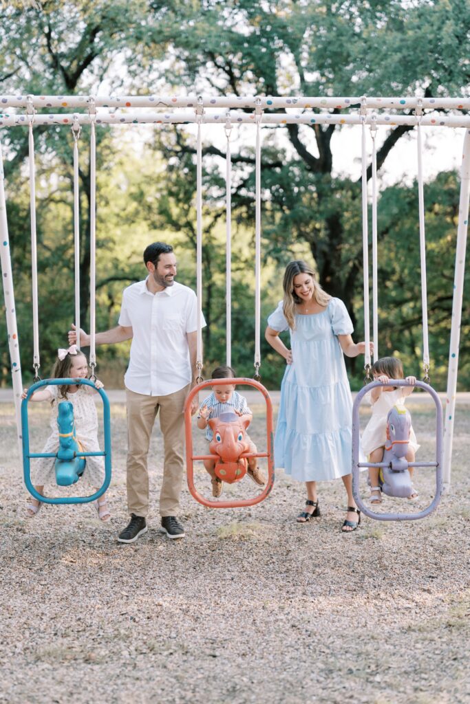 family of four playing on playground
