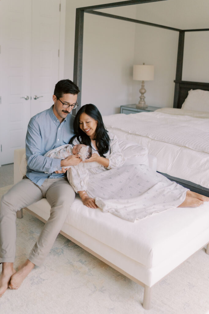 couple on bed with newborn baby by Newborn Photographers Colorado Springs