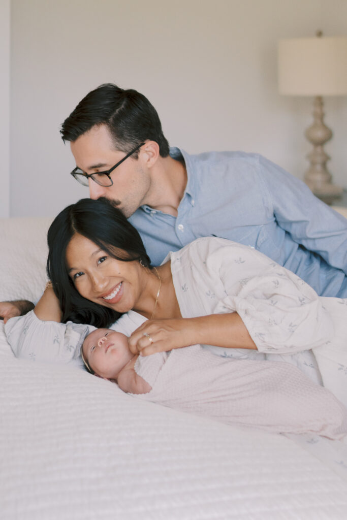 couple on bed with newborn baby by Newborn Photographers Colorado Springs