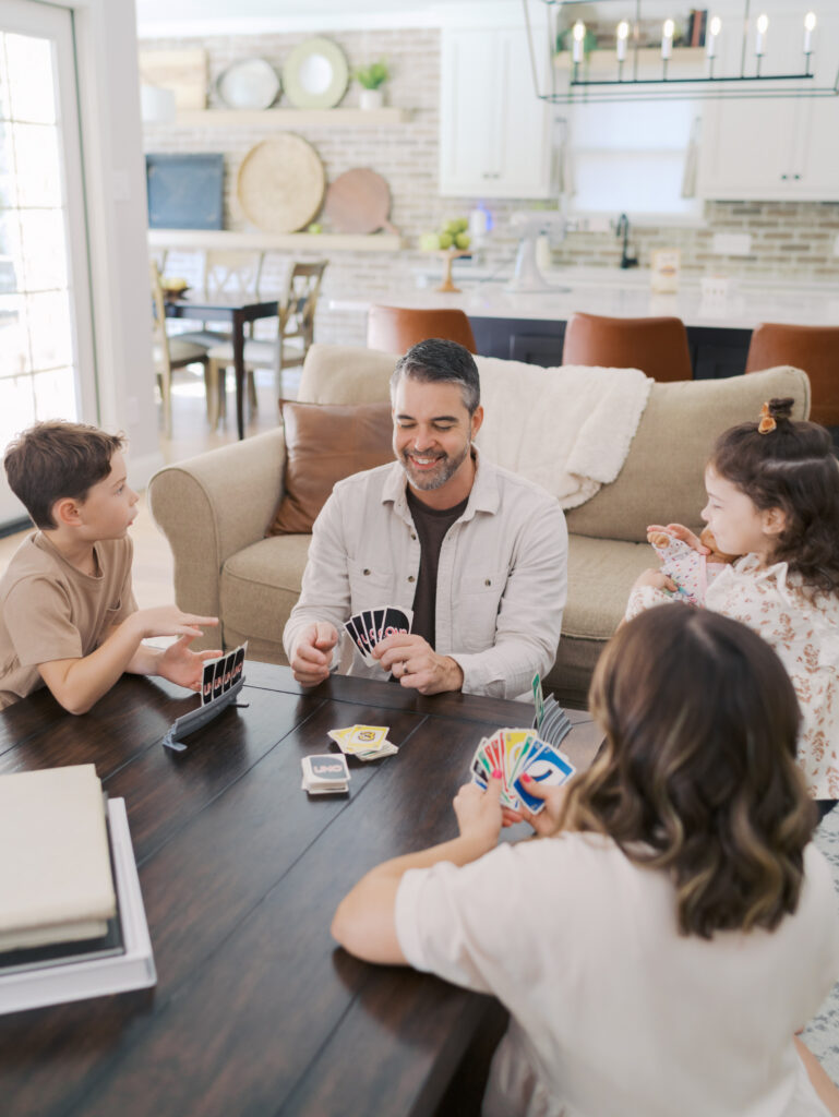 family of four play uno around the coffee table for Colorado in home family session