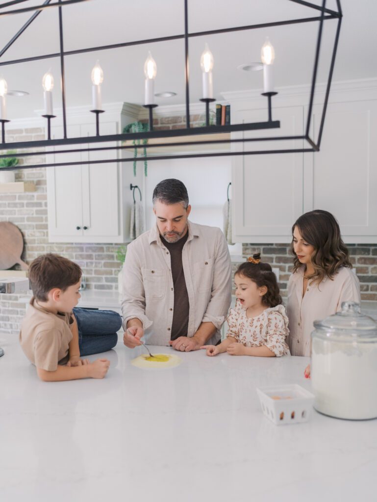 family of four in kitchen together making pasta for lunch