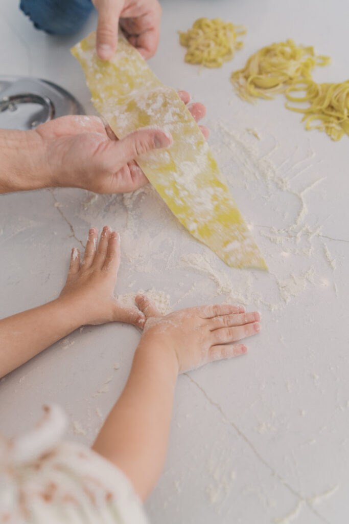 hands with homemade pasta on counter