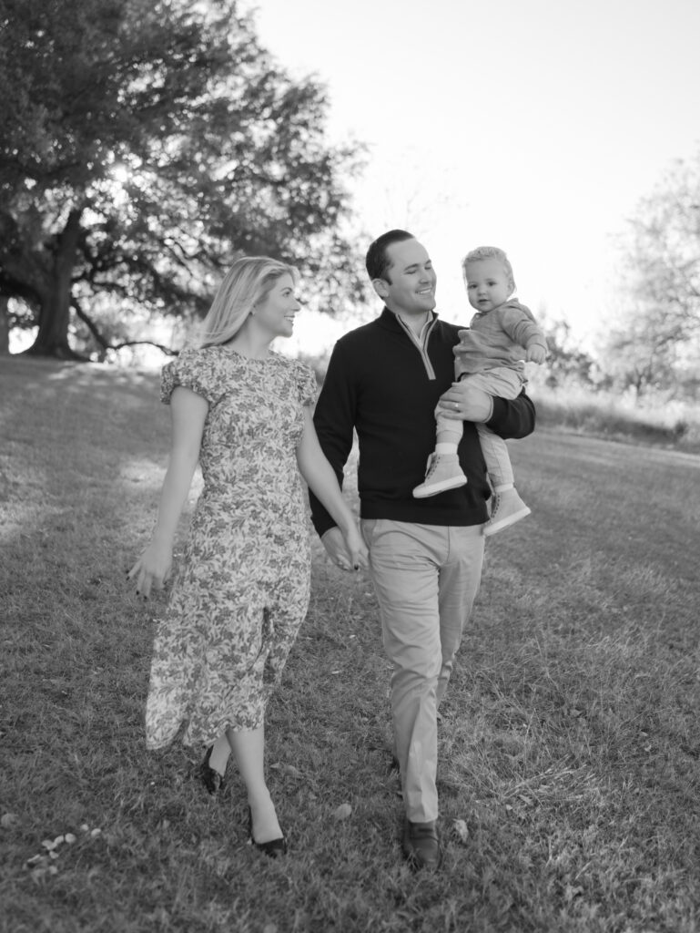 Family of three walking down a hill, dad carrying young son. Colorado Springs Family Photos by Lauren Bounds Photography