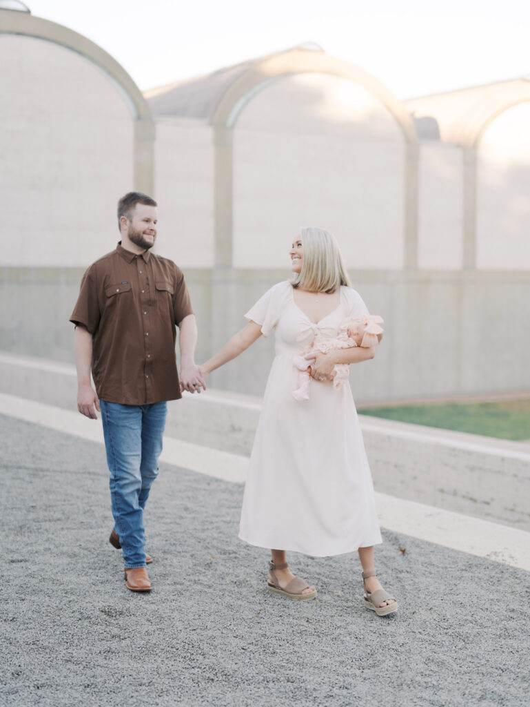 mom and dad walking with newborn for newborn photos in colorado springs, co
