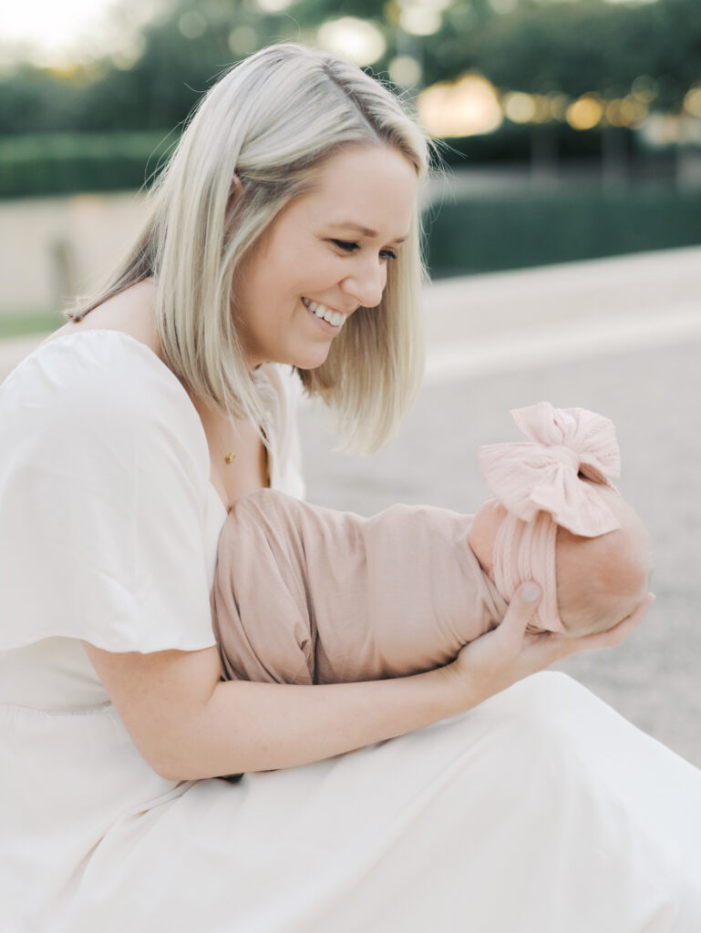 mom with newborn in arms smiling