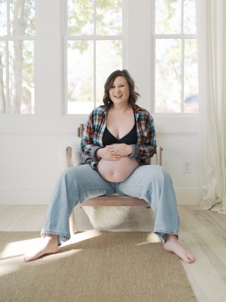 expecting mom sitting on chair showing pregnant belly