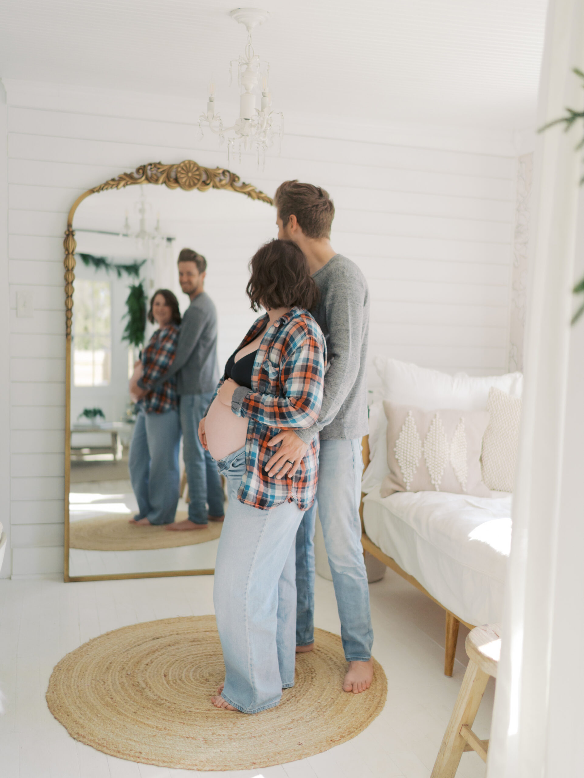 expecting couple front to back looking in floor mirror for colorado springs maternity photography