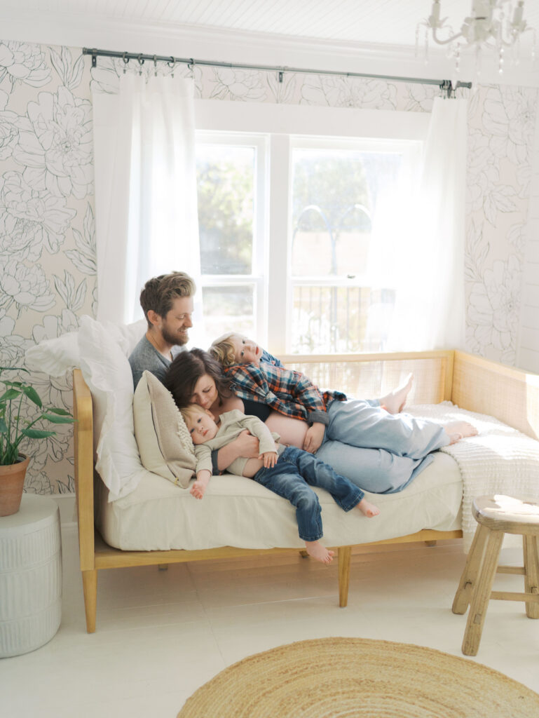 Colorado Springs Maternity Photographer family of four laying on bed with expecting mom