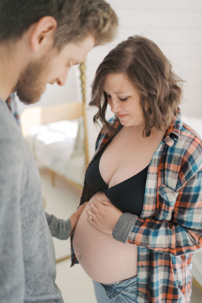 Colorado Springs Maternity Photographer Couple looking at baby bump