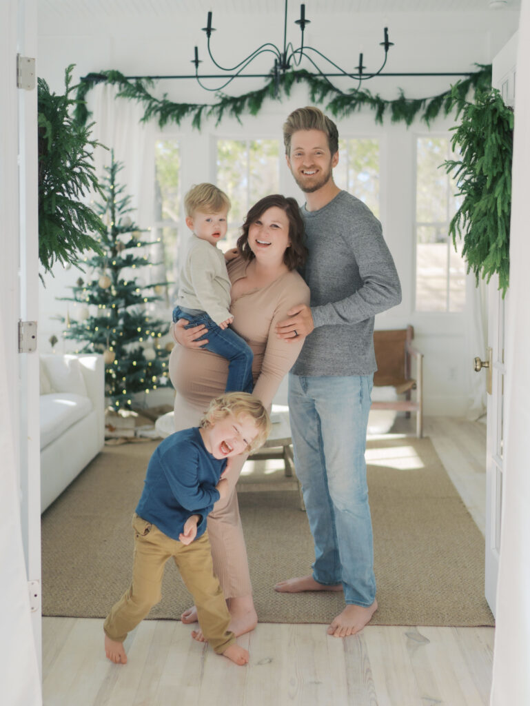 family of four laughing as they take a picture for Colorado Springs Maternity Photographer