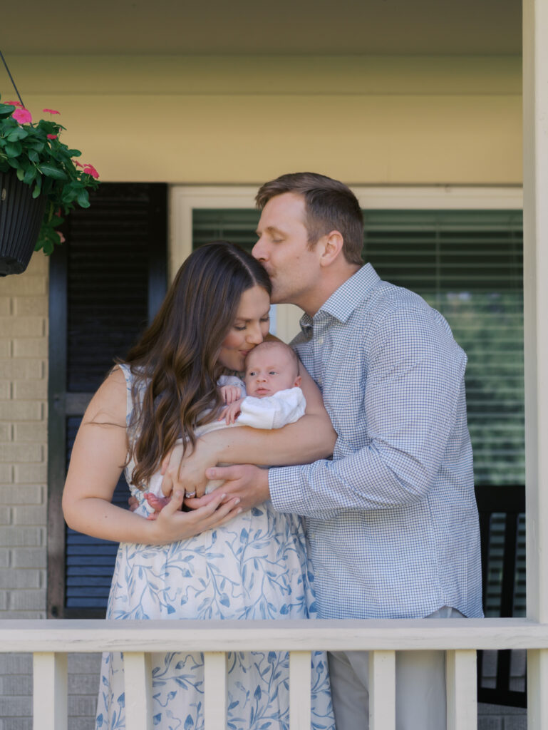 Colorado Springs Newborn Session dad kissing mom's head while she kisses baby