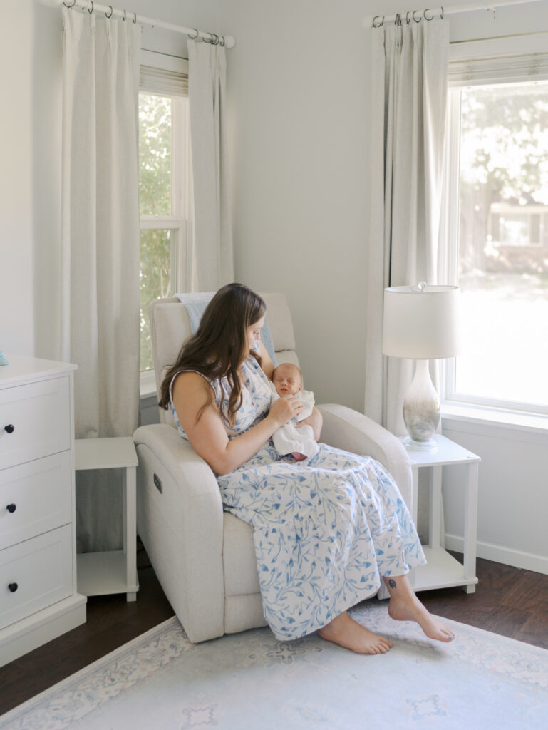 mom sitting in chair with newborn in nursery