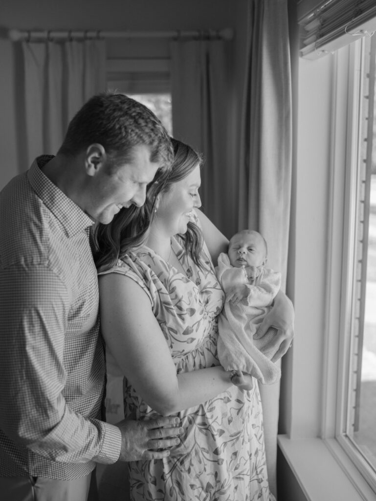 Colorado Springs Newborn Session parents holding baby facing window