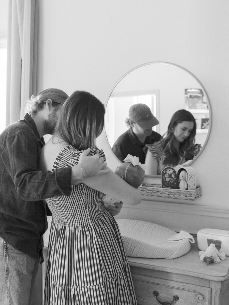 mom and dad with newborn in nursery 
