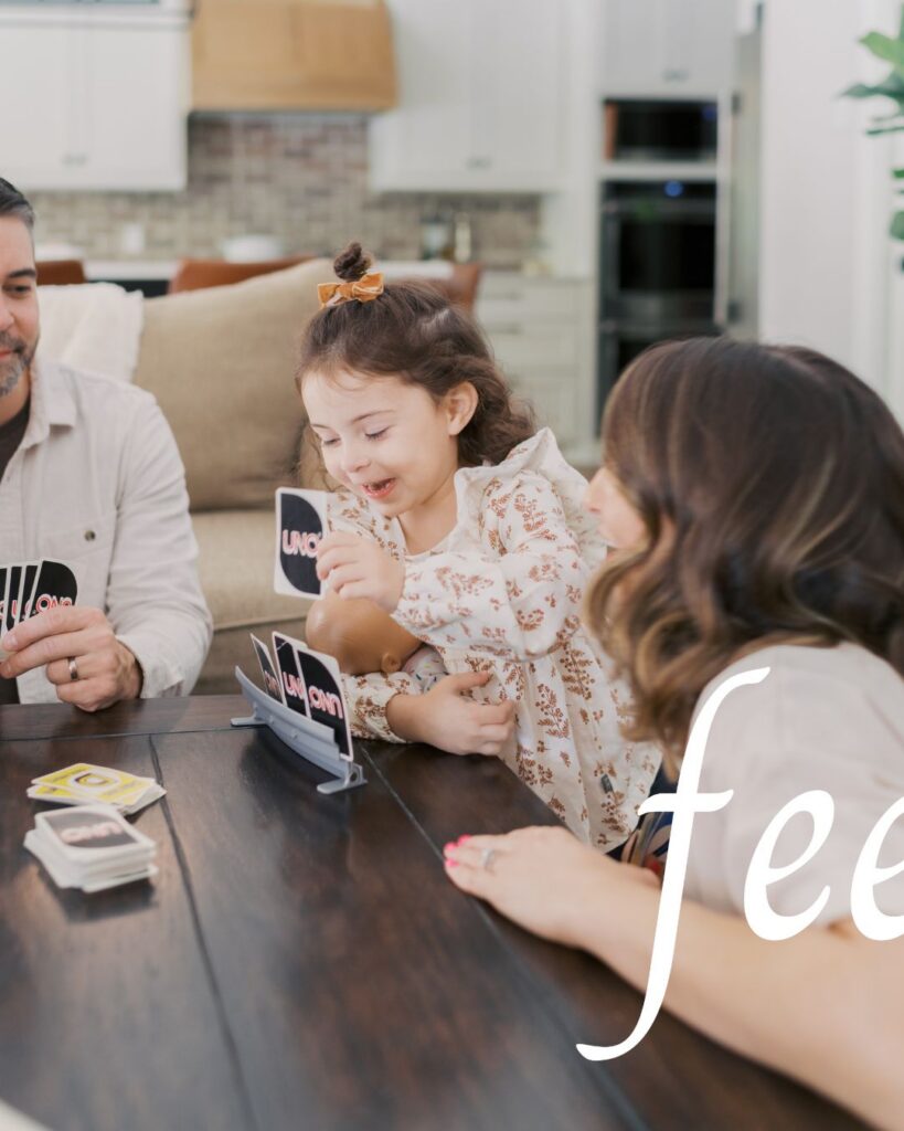 little girl smiling playing uno with family taken by Lauren Bounds Colorado Springs Family Photographer