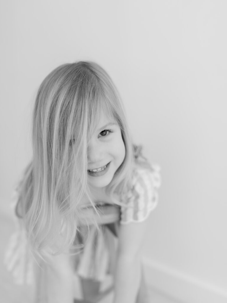 girls on top of stool with hair in face for Kid headshots, Lauren Bounds Photography in Colorado Springs, CO