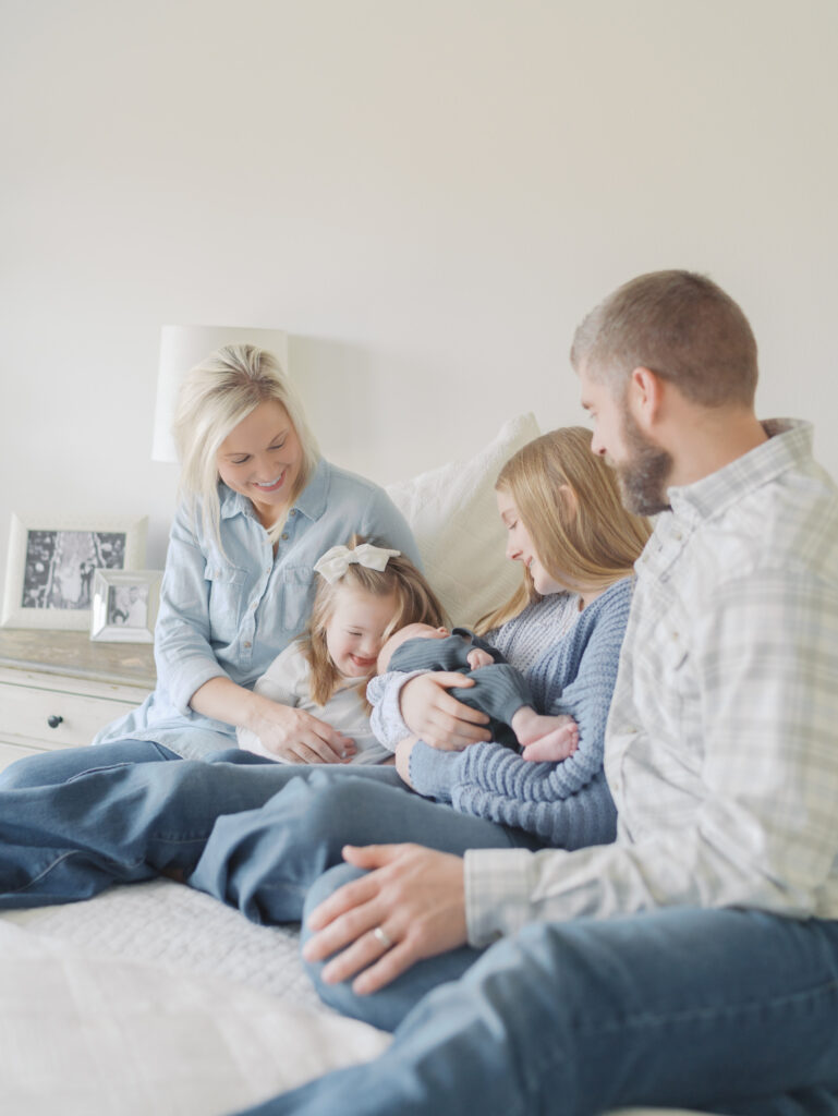family of five on bed with newborn baby Take better photos at home | Colorado Springs Newborn Photographer