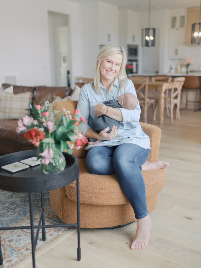 mom sitting in chair with newborn baby in arms for Take better photos at home | Colorado Springs Newborn Photographer
