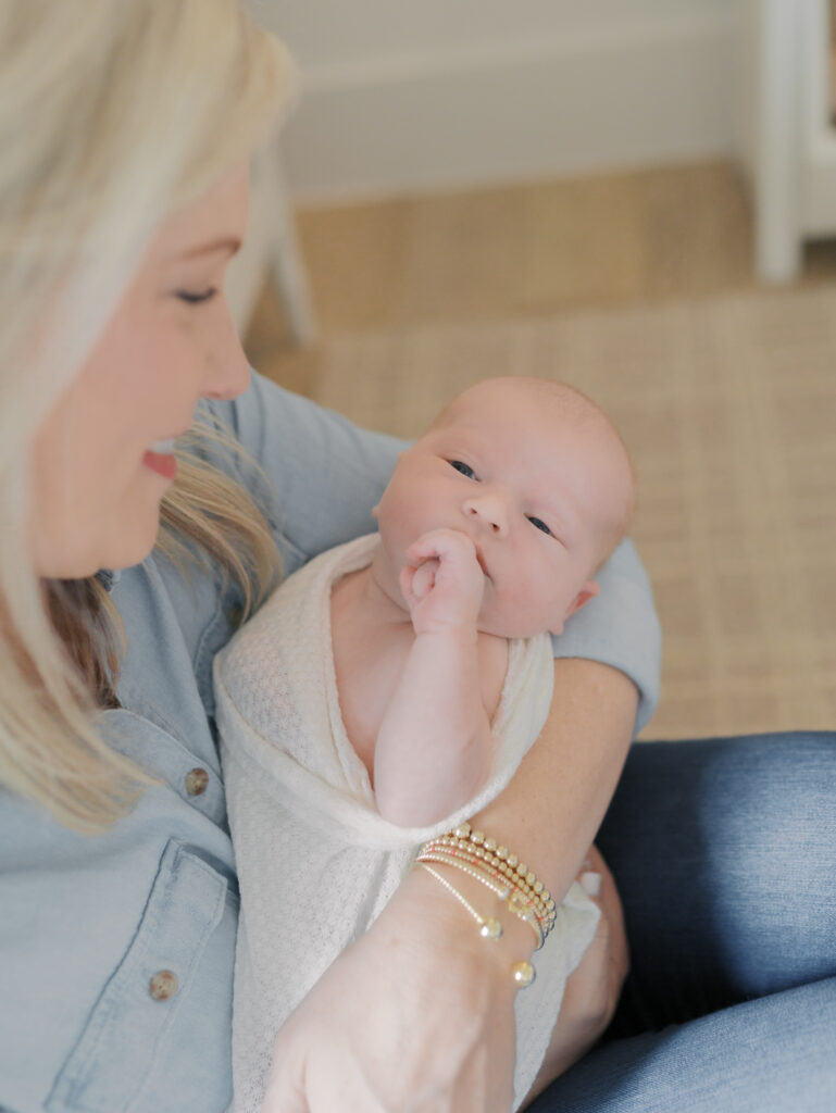 newborn in mom's arms with hand on mouth