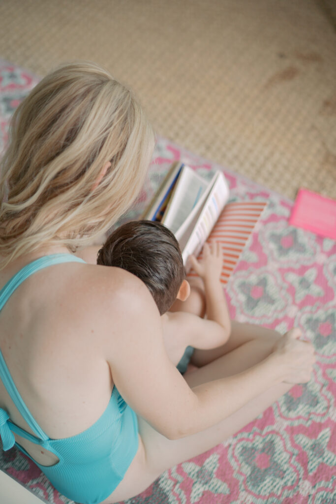boy sitting in moms lap looking at a book