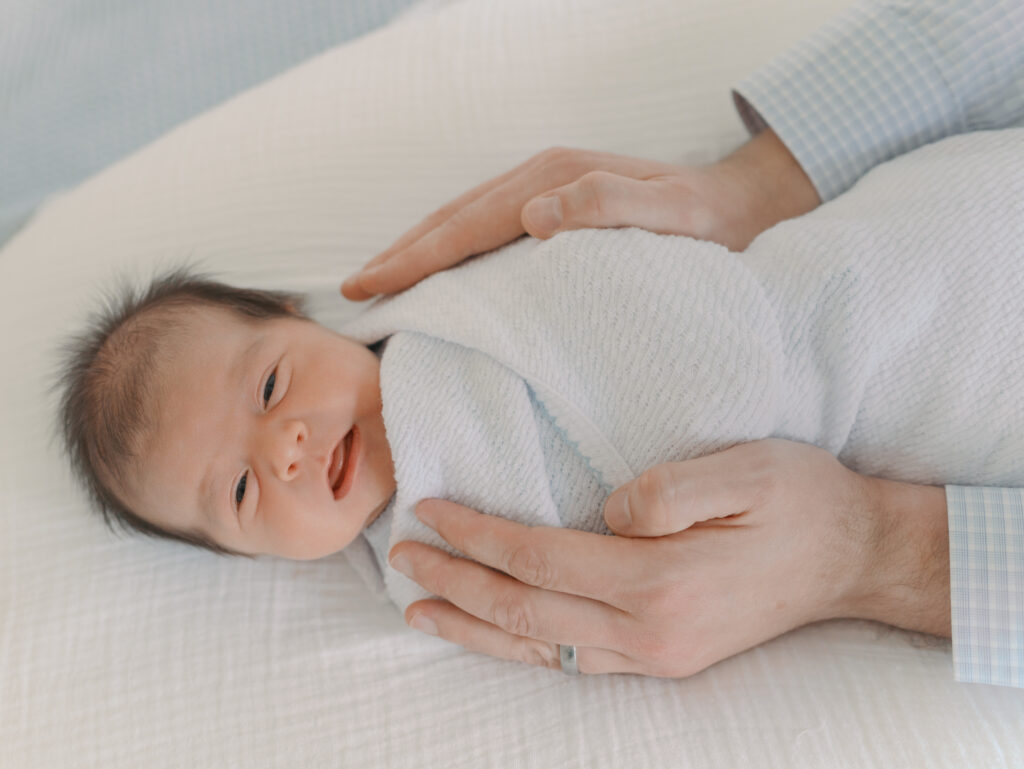 dad's hand wrapped around baby by Newborn Photographer Colorado Springs