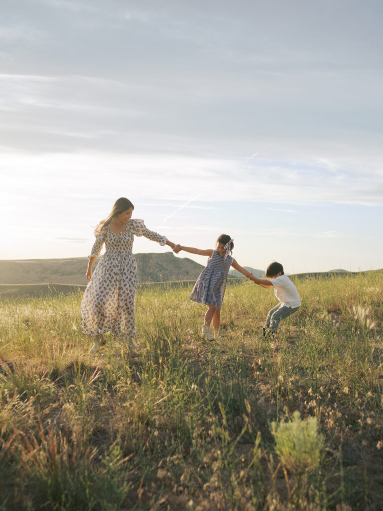 Mom and kids interacting as the walk through a meadow taken by Colorado Springs Photographer Lauren Bounds
