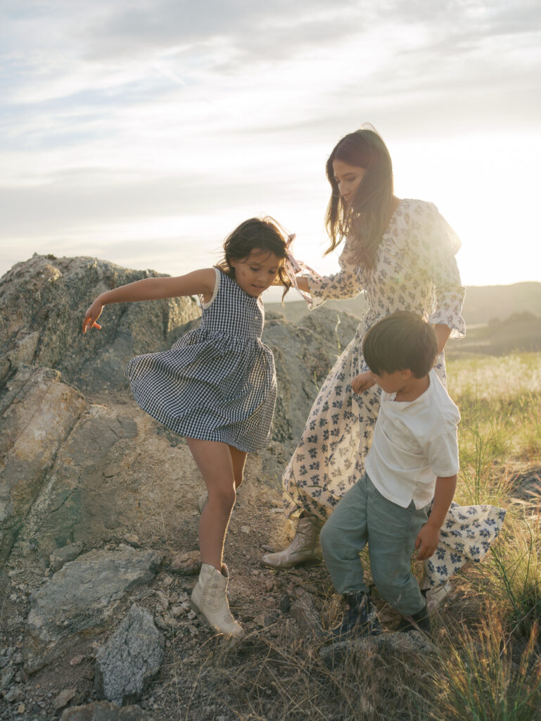 Family Adventure Photo Session photo of mom and two kids climbing on a rock and having fun.