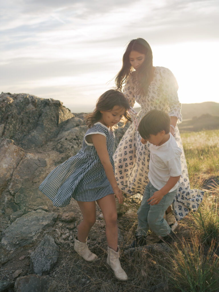 mom with two kids with the sunlight behind them casting a glow  during a Family Adventure Photo Sessions