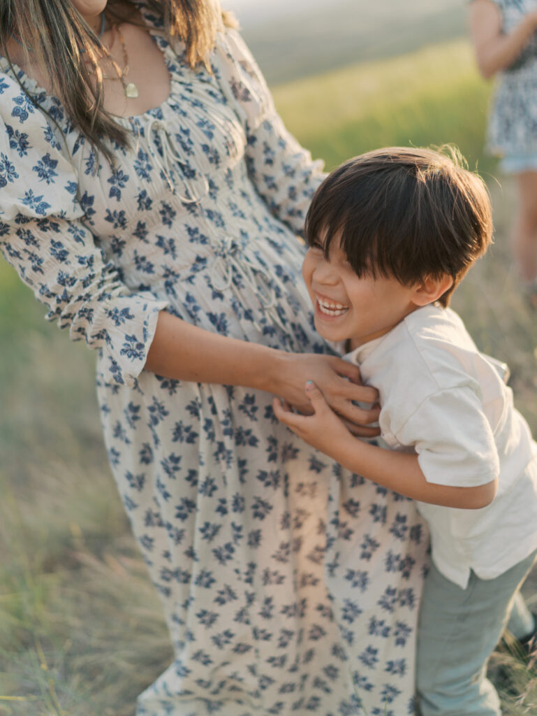 Close-up of mom tickling son as he laughs capture by Family Photographer in Colorado Springs.