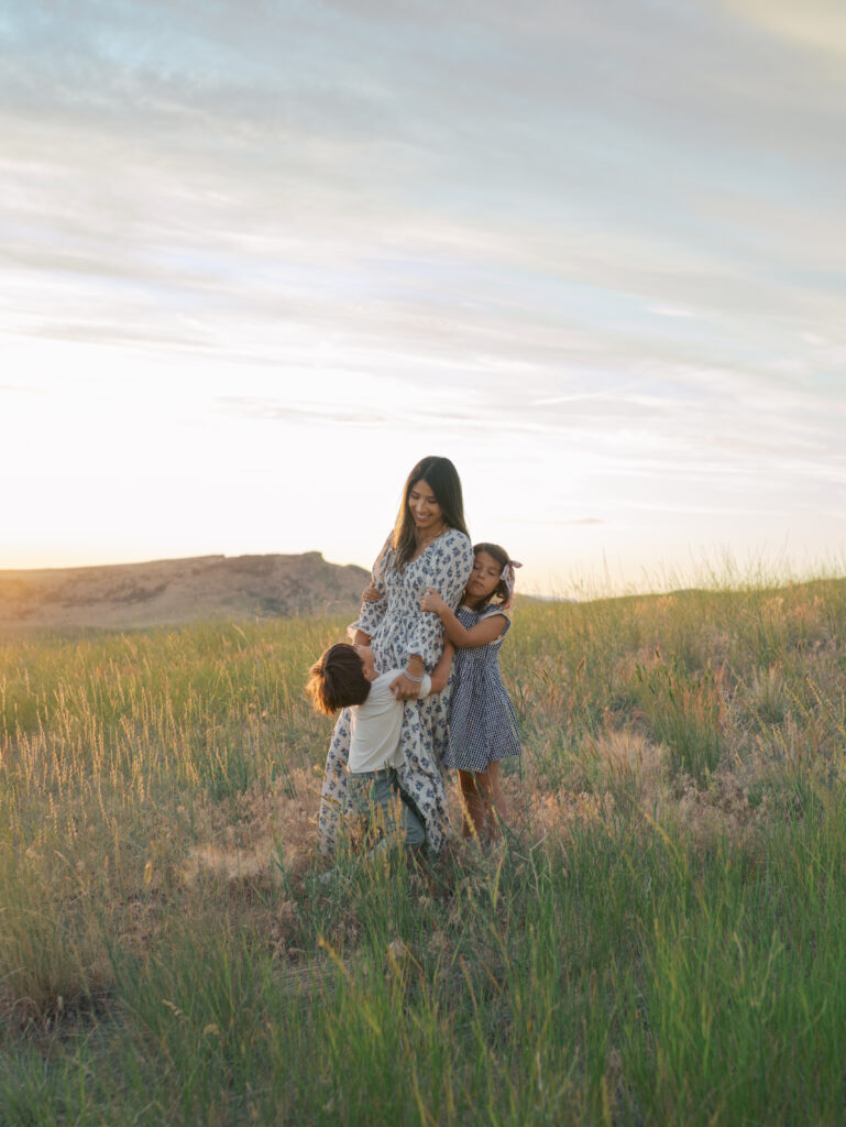 Family Adventure Photo Sessions moment of mom surrounded by kids hugging.