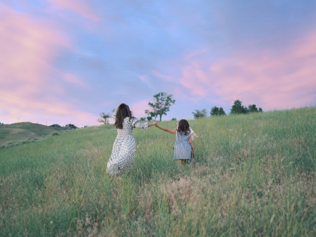 Mom and Kids running up a hill holding hands captured by Lauren Bounds- Family Photos Colorado Springs