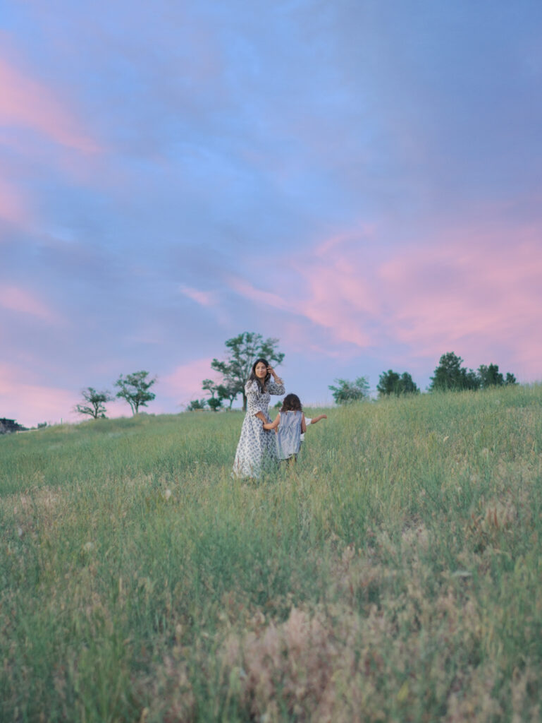 mom and kids in distance walking uphill, mom looking back at camera at a Adventure Family Photo Experience in colorado springs with Lauren Bounds Photography