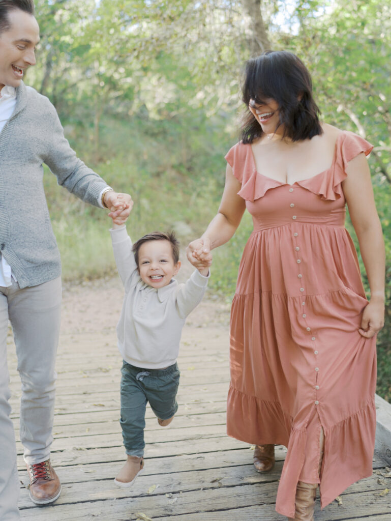 family running and laughing at Bear Creek Nature Center during a Colorado Springs Family Photo session 
