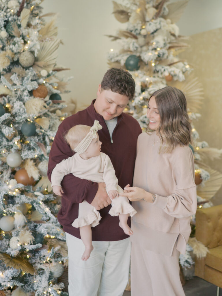 couple in front of christmas tree with baby at Family Photographers in Colorado Springs