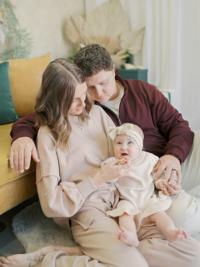 family in christmas setting by couch at photo studio in Colorado Springs