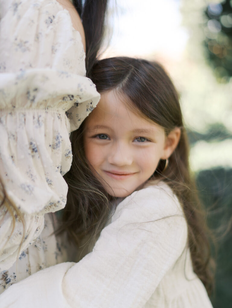 Family Photos Colorado Springs of young girl hugging mom from behind