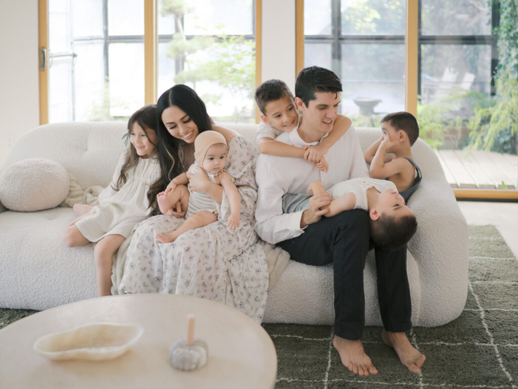 family of seven gathered on a couch interacting showing Family Photos Colorado Springs