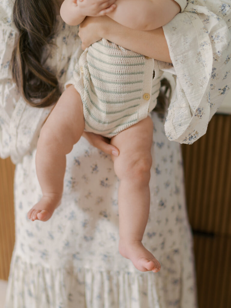 baby's chubby legs in moms arms