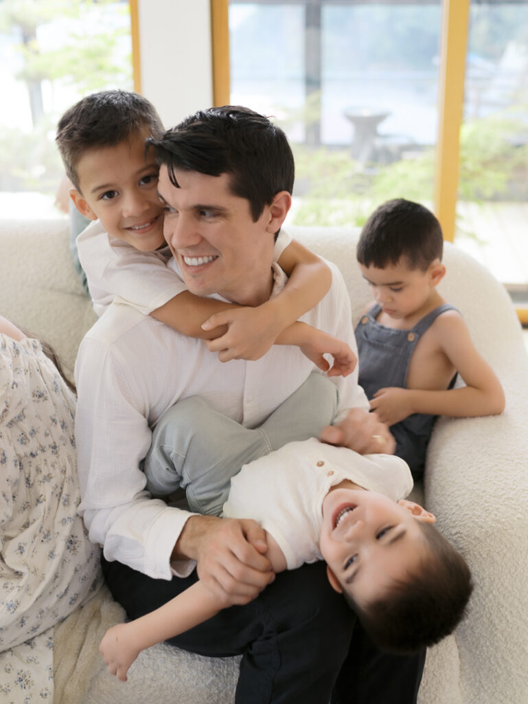 Family Photos Colorado Springs showing dad with three sons playing on couch