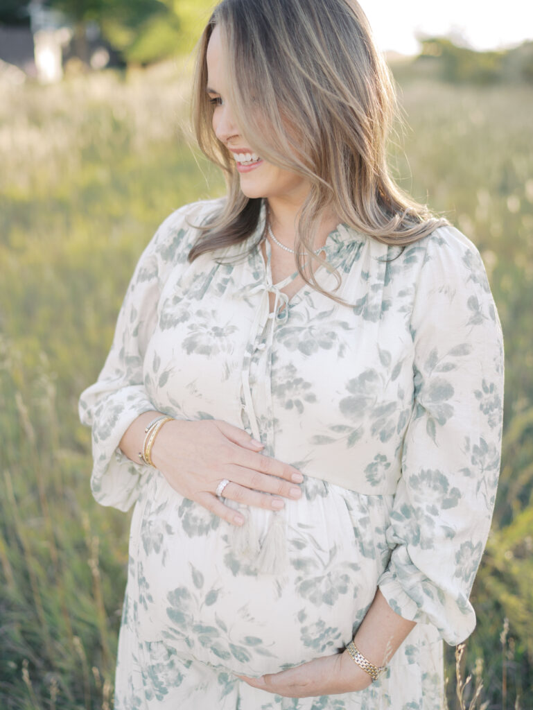 Pregnant mom smiling as she holds her belly at a Colorado Springs Maternity Photography session with Lauren Bounds