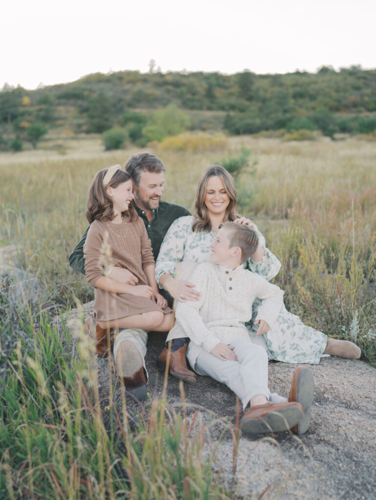 family sitting on rock in colorado during a Colorado Springs Maternity Photography session with Lauren Bounds
