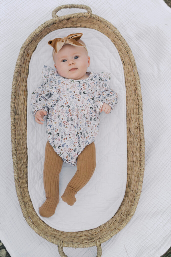 baby laying in basket smiling by colorado springs newborn photographer