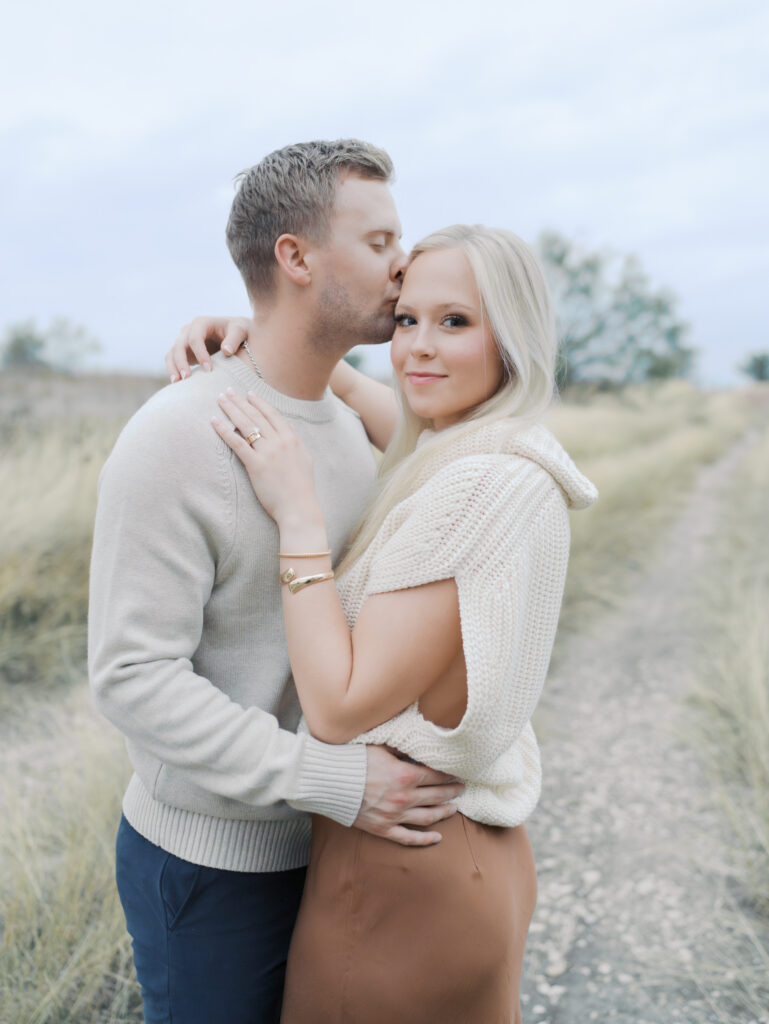 couple embracing while wife looks at camera by lauren bounds photography