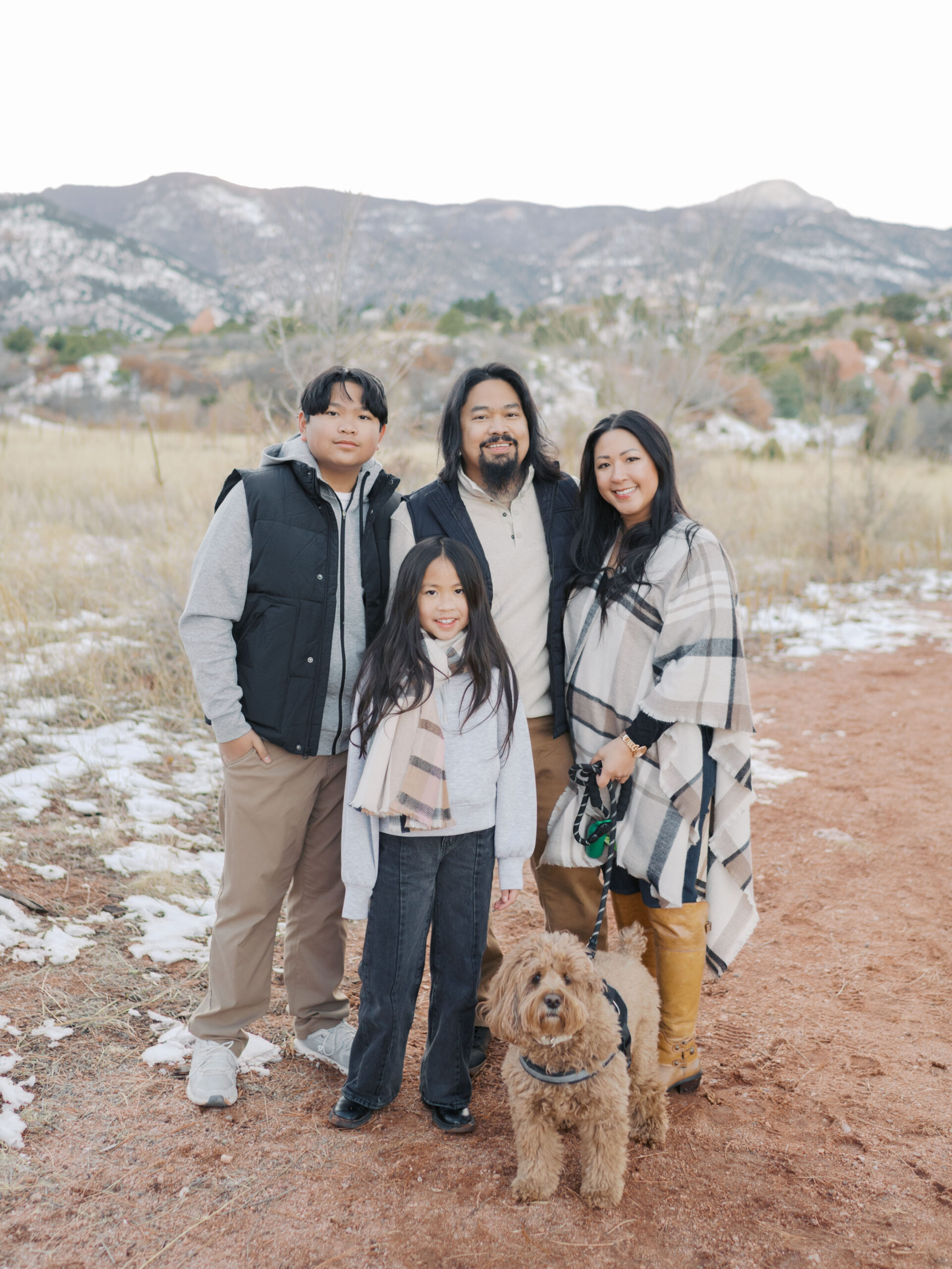 family of four at red rock open space in colorado springs, mountains in the background