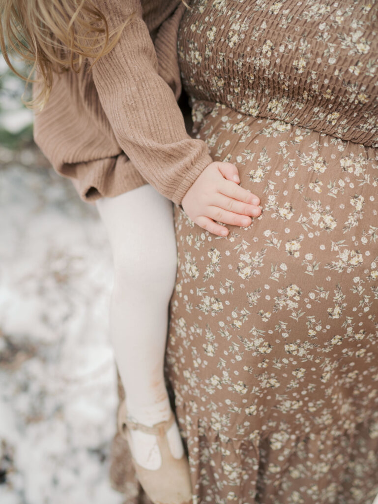 toddlers had on pregnant moms belly at Garden of the Gods during a Colorado Springs Maternity Session showing what to wear for maternity photos