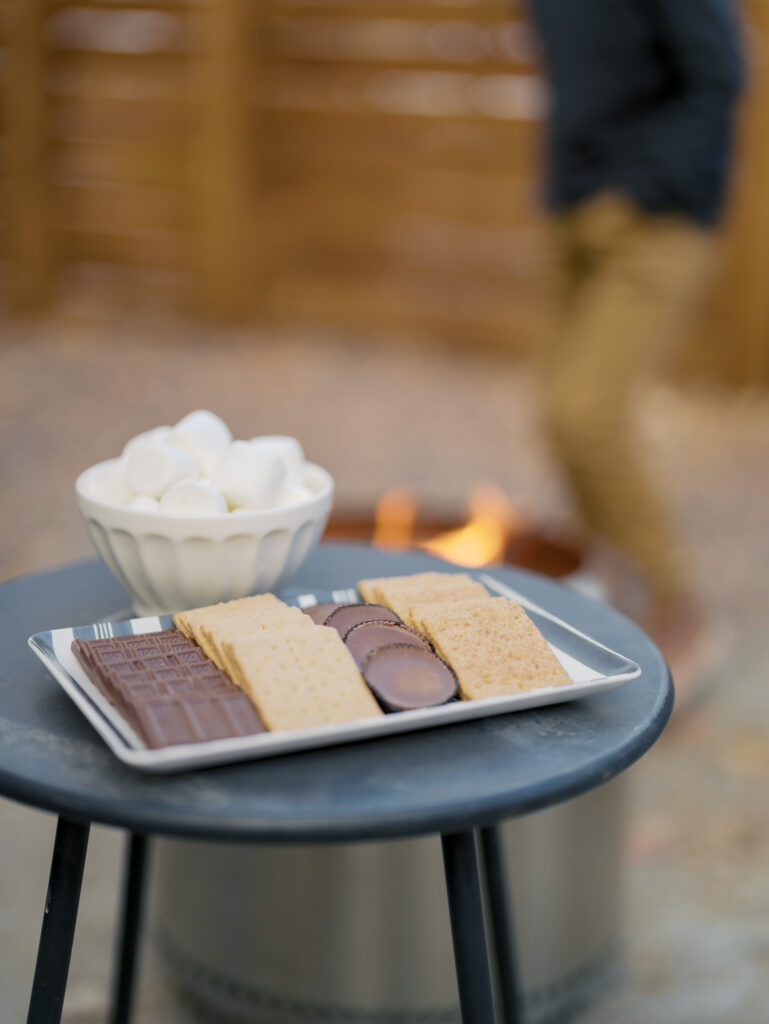 bowl of marshmallows with chocolate and graham crackers sitting by a fire ready to be roasted showing Winter Activities in Colorado Springs