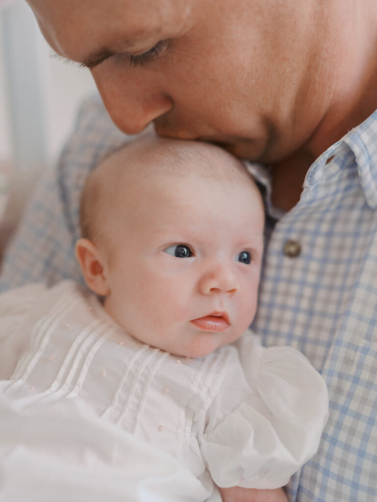 dad resting chin on newborns head 