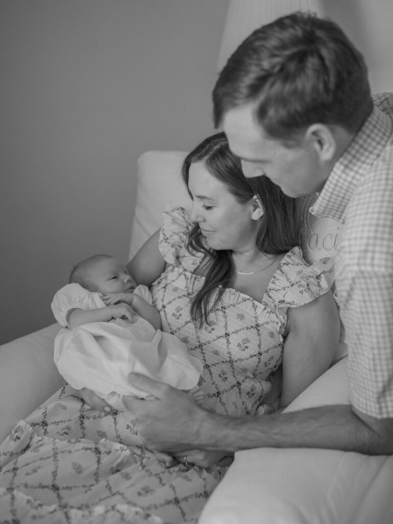 couple and newborn in nursery sitting on chair for post about summer concerts in Colorado Springs