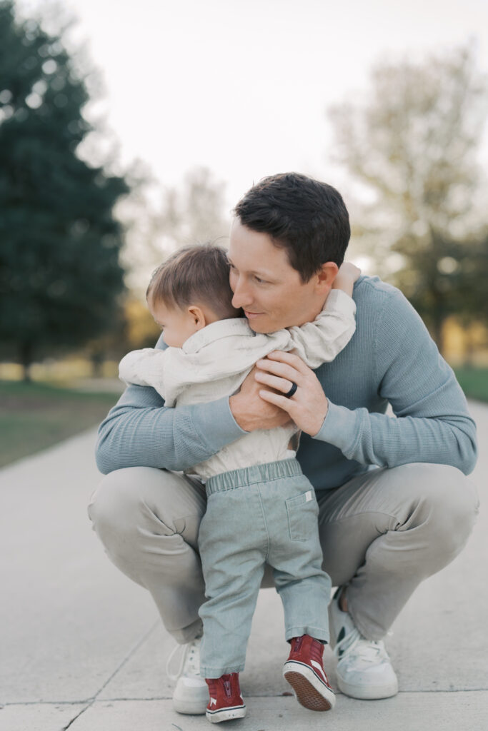 little boy hugging kneeling dad with arms wrapped around each other