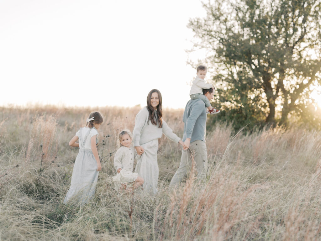 family holding hands walking in a field at a Colorado Springs family session by Lauren Bounds Photography